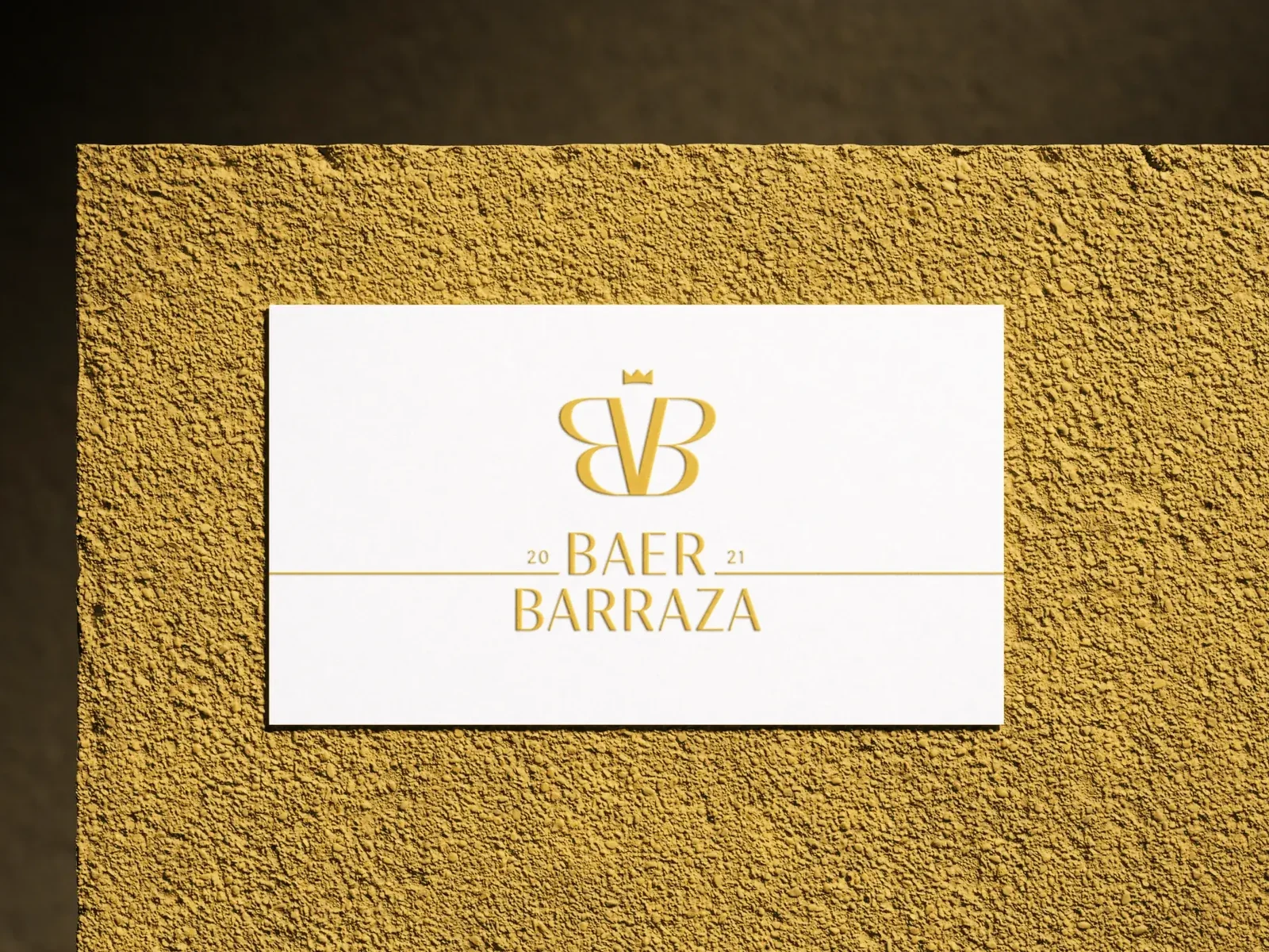 Baer & Barraza business card with the gold crowned monogram on a textured gold wall