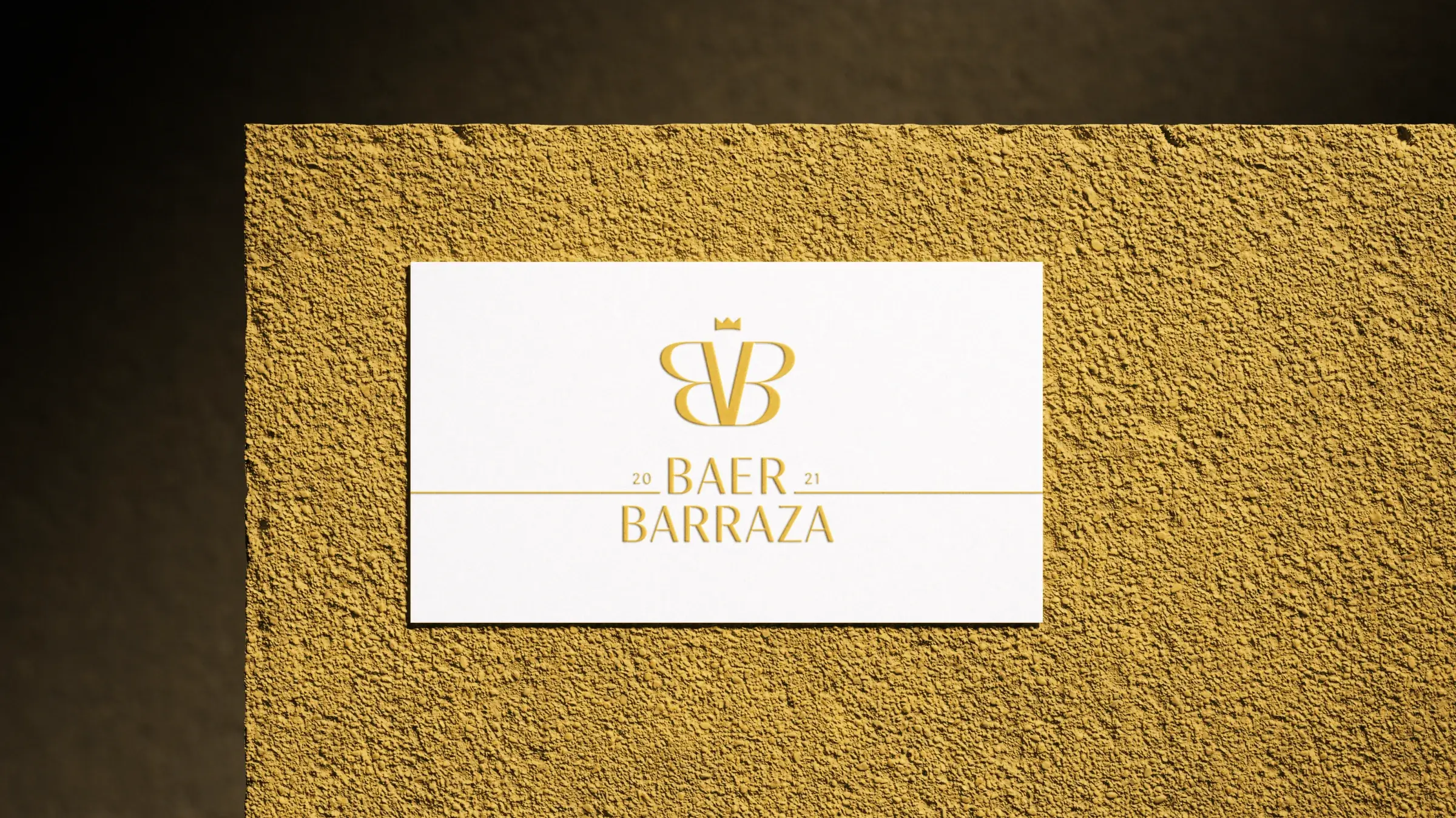 Business card with the monogram and wordmark in gold on a textured gold wall