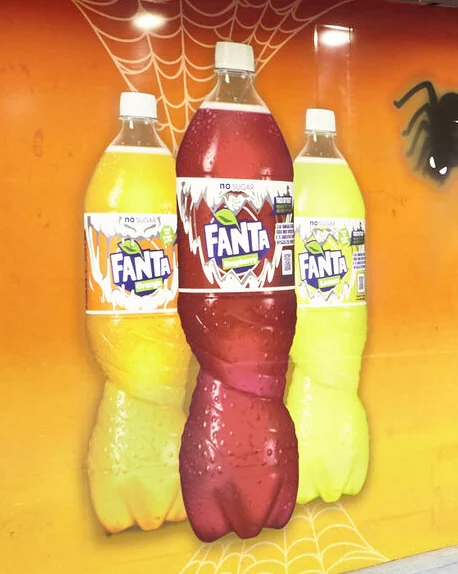 Close-up of three Fanta Halloween bottles in a spider web