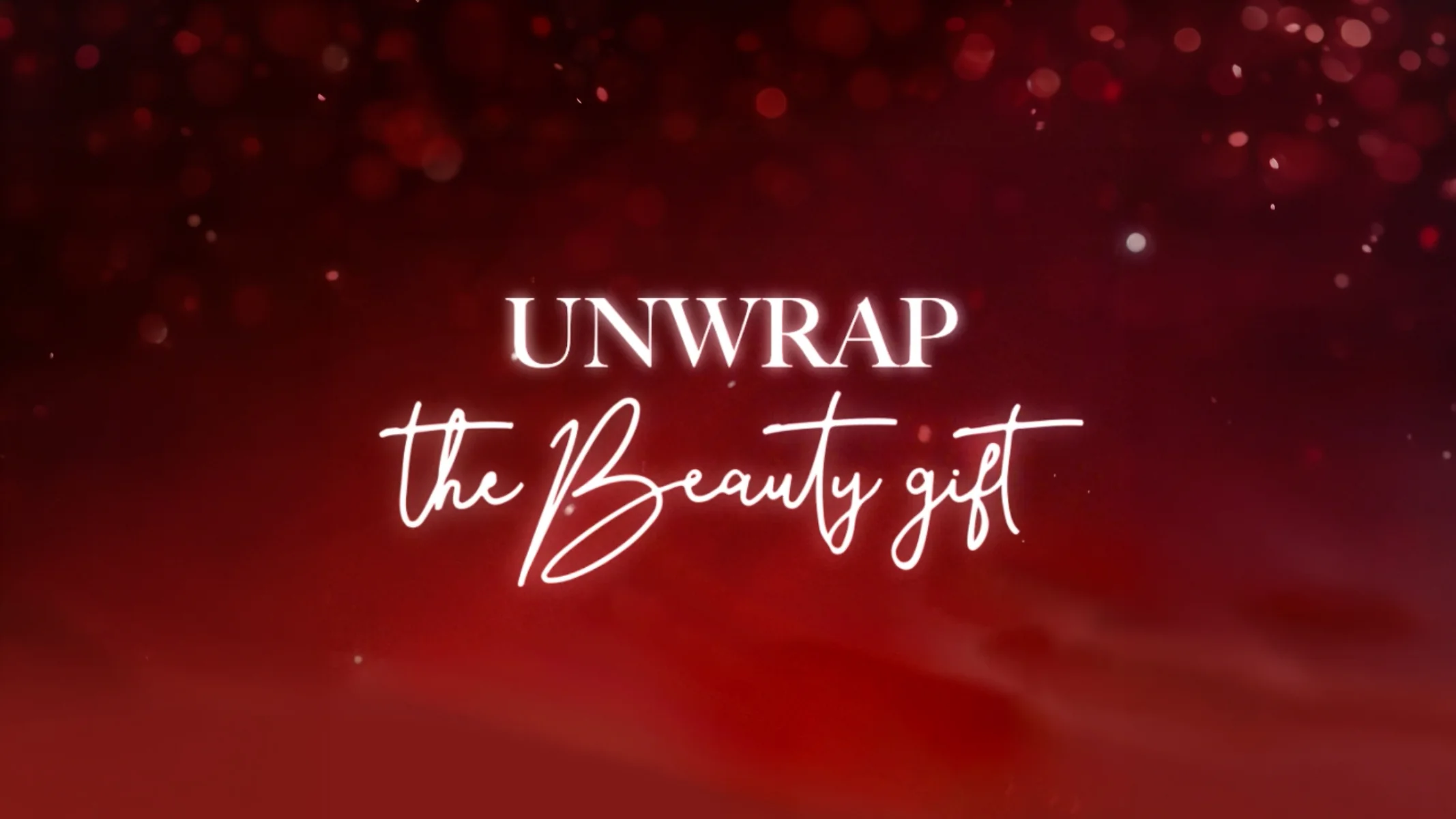 Key visual: Unwrap the Beauty gift, on a deep red background with sparkles