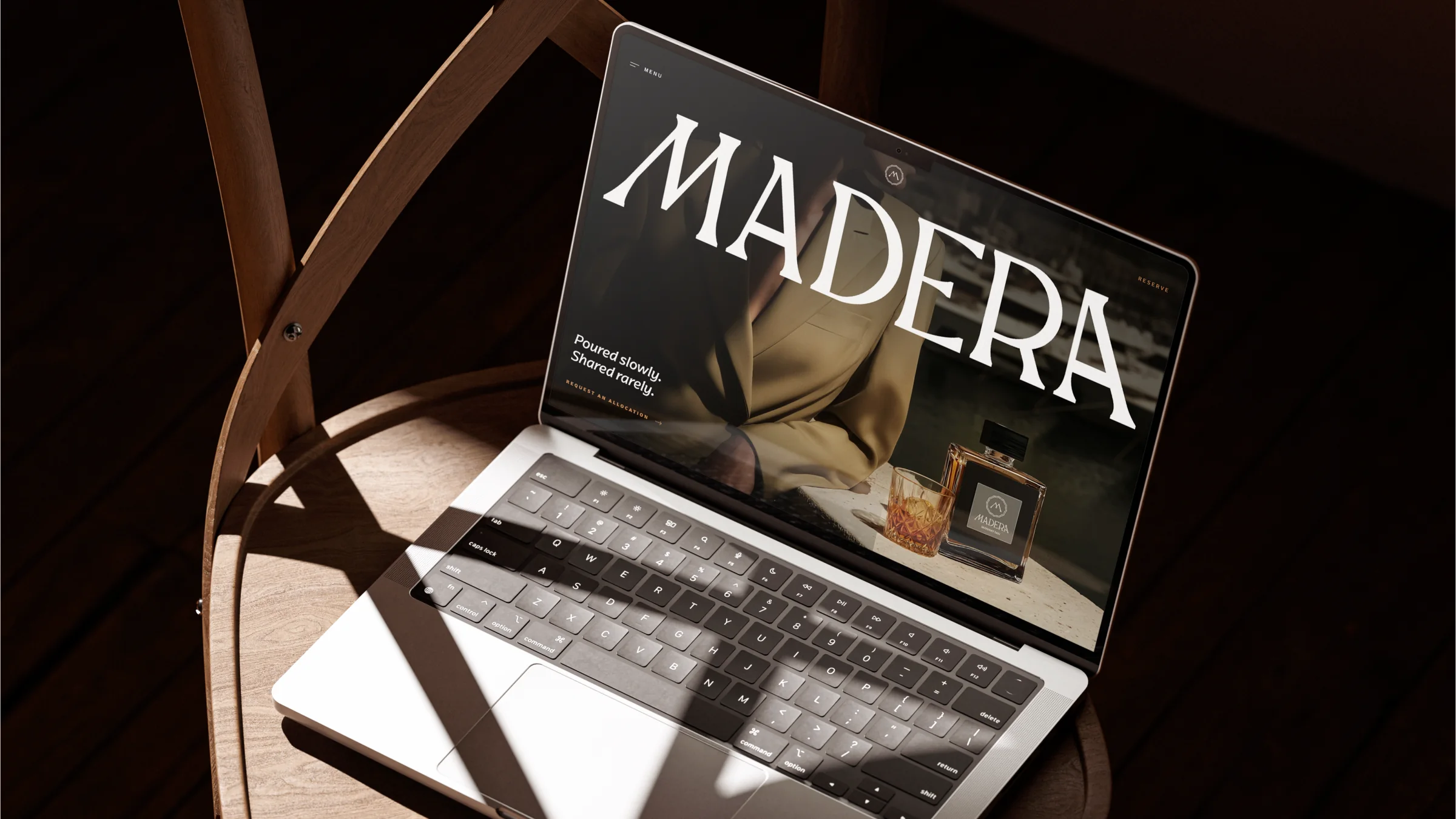 Madera website on a laptop resting on a wooden chair in warm light